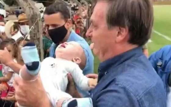 Bolsonaro, sem máscara provoca aglomeração e segura criança